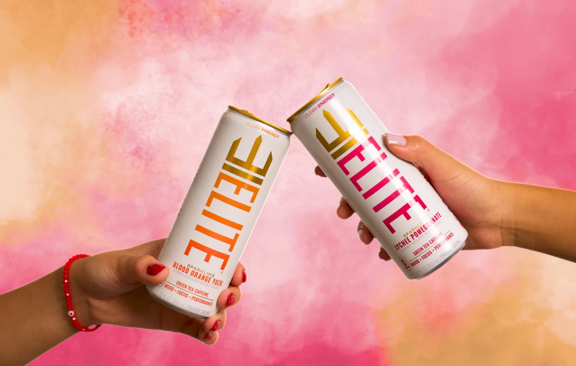 Two friends toasting cans of ELITE Blood Orange Yuzu and Lychee Pomegranate